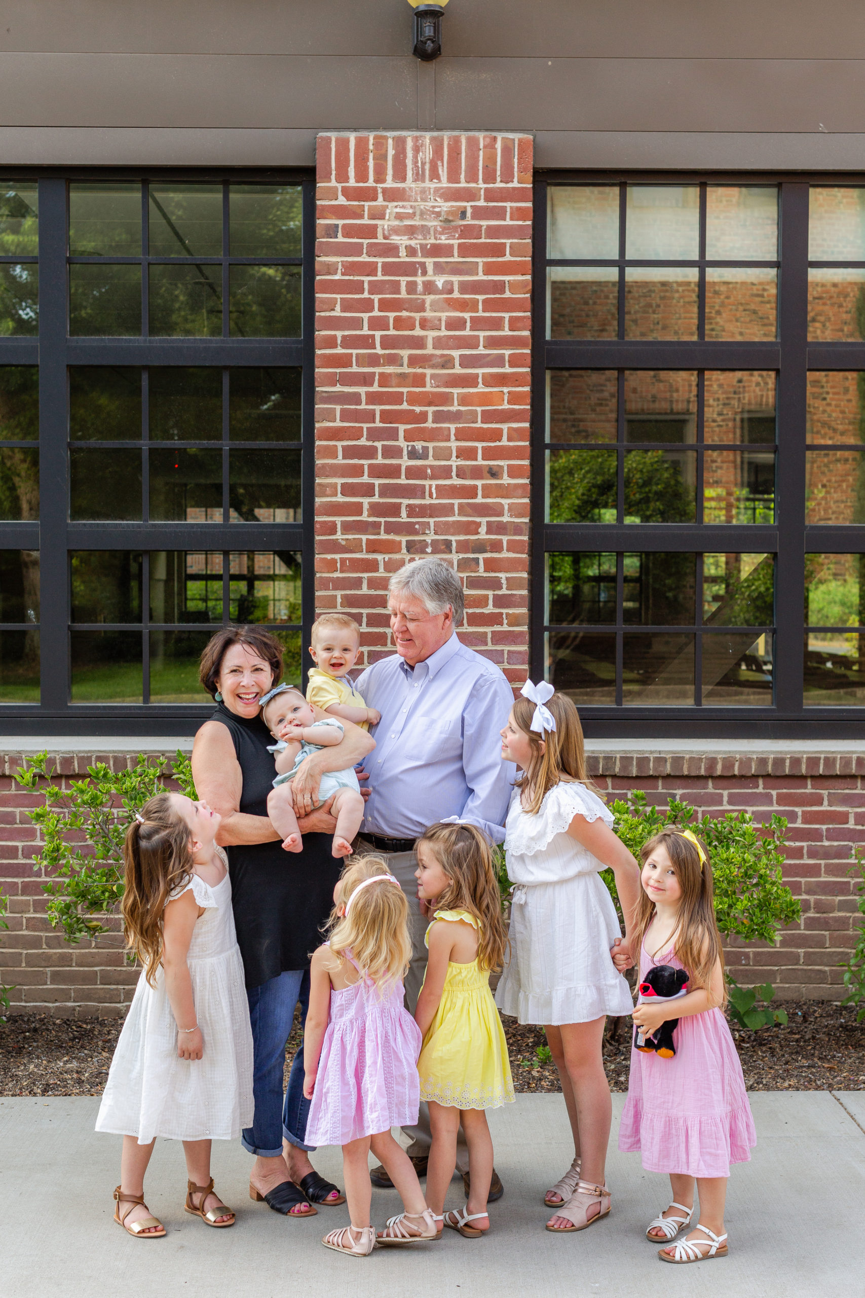 Large Extended Family Grandparents with Grandchildren with Brick Building | Mary + Don